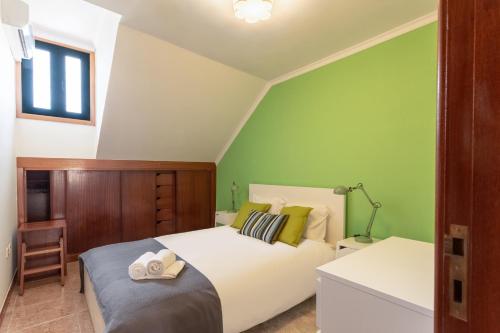 Un dormitorio con una cama blanca y una pared verde. en Porto Residence Campanhã, en Oporto