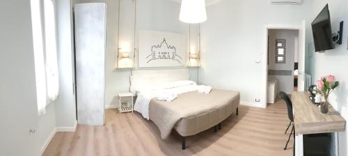 ローマにあるB&B Aurelia Garden Roomsの白いベッドルーム(ベッド1台、テーブル付)