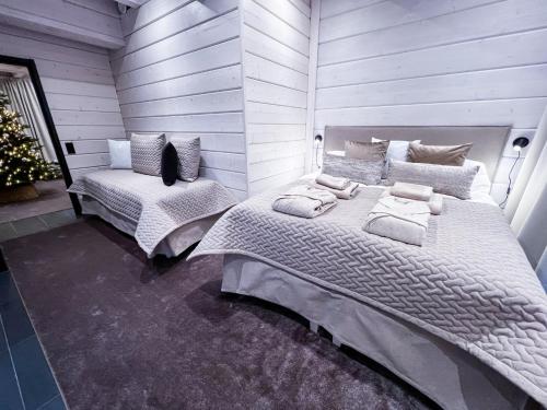 um quarto com duas camas e uma árvore de Natal em Santa's Luxury Boutique Villa, Santa Claus Village, Apt 1 em Rovaniemi