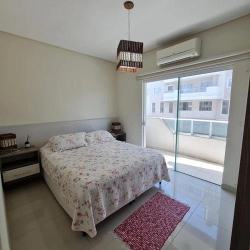 1 dormitorio con cama y ventana grande en novo e aconchegante apartamento a 90 metros da praia de bombinhas, en Bombinhas