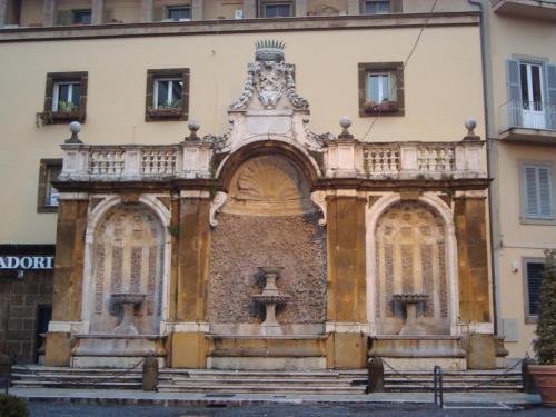 an old building with a clock on top of it at Galleria Frascati Rooms and Apartment in Frascati