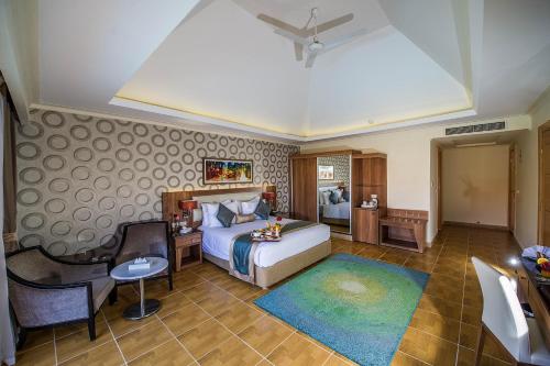 a bedroom with a bed and a table and a chair at Pickalbatros Aqua Blu Sharm El Sheikh in Sharm El Sheikh