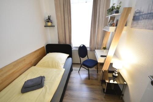 a small room with a bed and a chair in it at Pension am Schloss in Schwerin