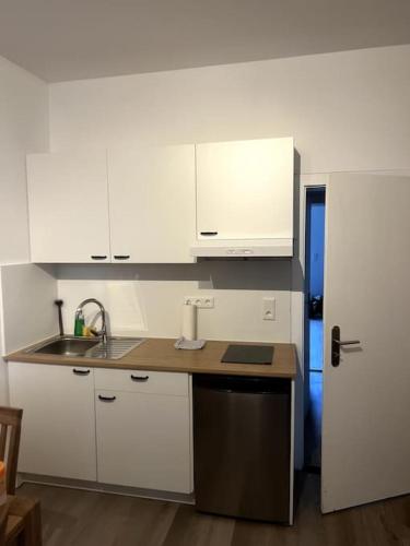 a kitchen with white cabinets and a sink at Geräumiges Apartment am Hafen von Dortmund in Dortmund