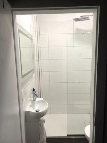 a white bathroom with a sink and a shower at Geräumiges Apartment am Hafen von Dortmund in Dortmund