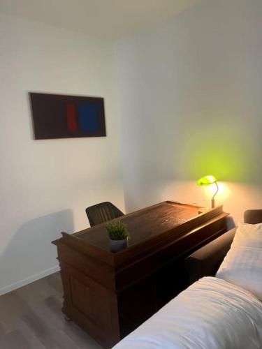 a desk in a bedroom with a bed and a lamp at Geräumiges Apartment am Hafen von Dortmund in Dortmund