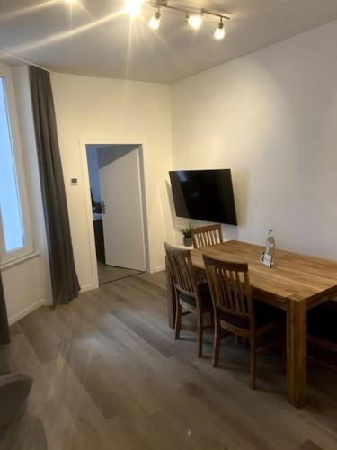 a dining room with a wooden table and chairs at Geräumiges Apartment am Hafen von Dortmund in Dortmund