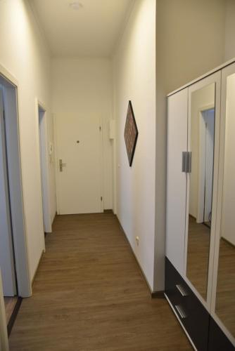 an empty hallway with white walls and wood floors at Pension am Schloss in Schwerin