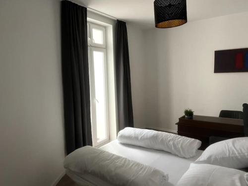 a bedroom with a white bed and a window at Geräumiges Apartment am Hafen von Dortmund in Dortmund