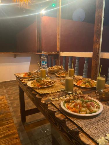 a table with plates of food and drinks on it at Imsouanegreenwave in Imsouane