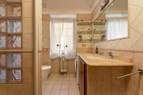 bagno con lavandino, servizi igienici e specchio di La Casa del Mare a Lido di Ostia