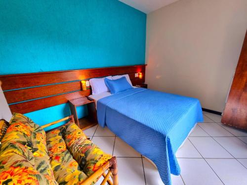 a bedroom with a bed and a couch in it at Pousada Aquarela do Mar in Abraão