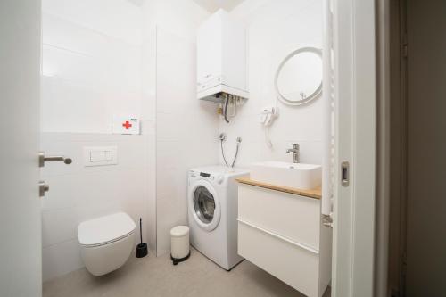 een witte badkamer met een wasmachine en een wastafel bij Mannequin: Sea view, private parking in the garage in Rijeka
