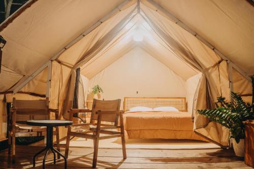 1 dormitorio en una tienda de campaña con 1 cama y 1 mesa en Alamu Eco Lodge en Bedugul