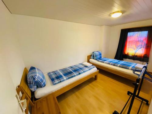 two beds in a room with a window at Matten Central Residences in Matten