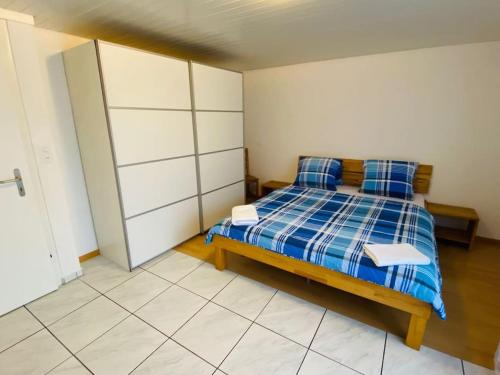 a bedroom with a bed with two blue pillows at Matten Central Residences in Matten