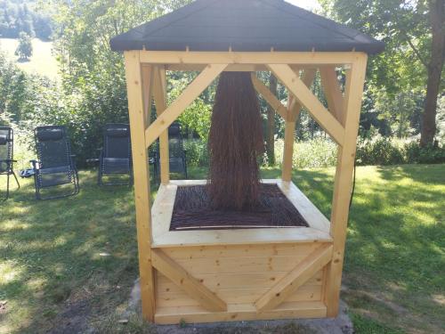 a wooden gazebo with a tree in it at Osada Sudecka in Lądek-Zdrój