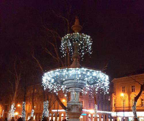 a fountain with christmas lights in front of a building at Čarobni pogled Zagreb in Zagreb