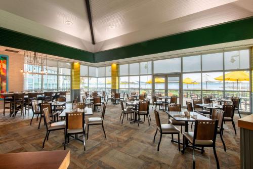 a dining room with tables and chairs and windows at 41 Lakefront Hotel, Trademark Collection by Wyndham in Geneva