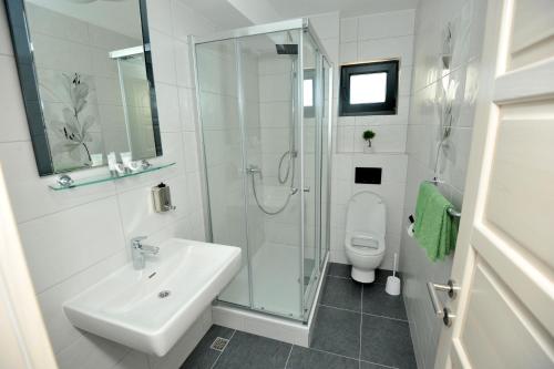 y baño con lavabo, ducha y aseo. en Apartments Villa Tomislav en Brela