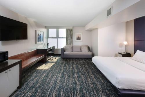 日內瓦的住宿－41 Lakefront Hotel, Trademark Collection by Wyndham，酒店客房设有一张大床和一台电视。
