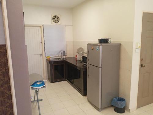 a kitchen with a stainless steel refrigerator and a counter at Twin Luck Home Stay in Ipoh