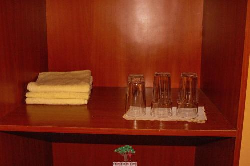 a shelf with three glasses and towels on it at Oldarpoi Wageni Camps in Keekorok