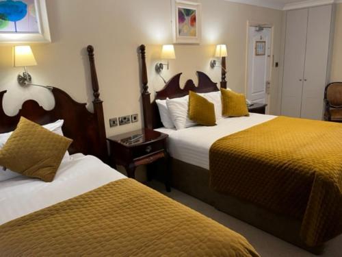 a hotel room with two beds with yellow pillows at Atlantic Hotel in Lahinch