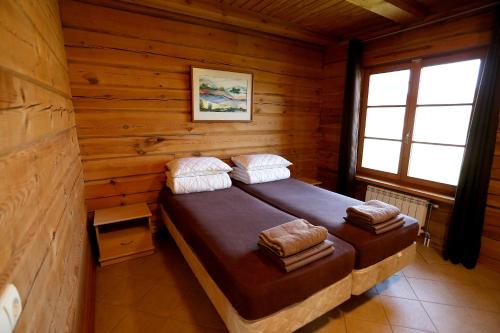 1 dormitorio con 1 cama en una cabaña de madera en Sodyba šeimai "Obuolių namai", en Gaylyunay