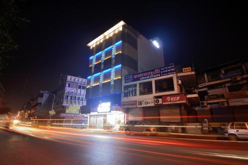 a building with blue lights on a city street at night at Hotel One Up in Ahmedabad