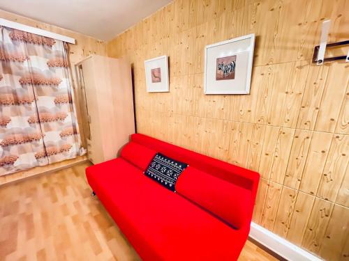 a red couch in a room with wood paneling at Weisses Rössli in Leukerbad