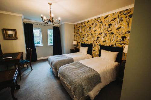 a hotel room with two beds and a desk at Brook Hall Hotel in Childer Thornton