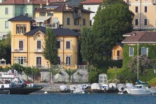 un grupo de barcos atracados en el agua cerca de edificios en Villa Torretta, en Varenna