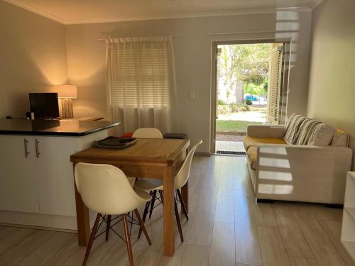 a kitchen and living room with a table and chairs at Happy Home Rondebosch in Cape Town