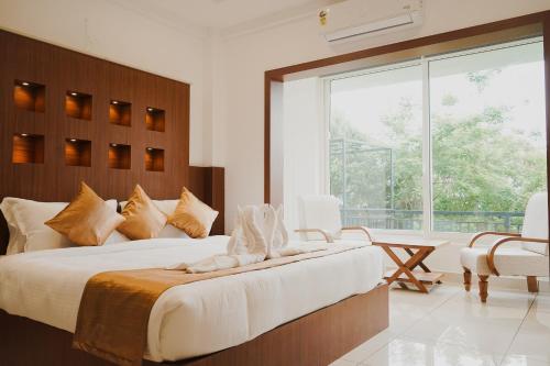a bedroom with a large bed and a large window at Sprise Munnar Resort and Spa in Munnar