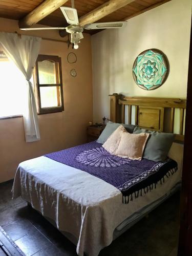 1 dormitorio con 1 cama con manta morada en Casa Luna en San Rafael