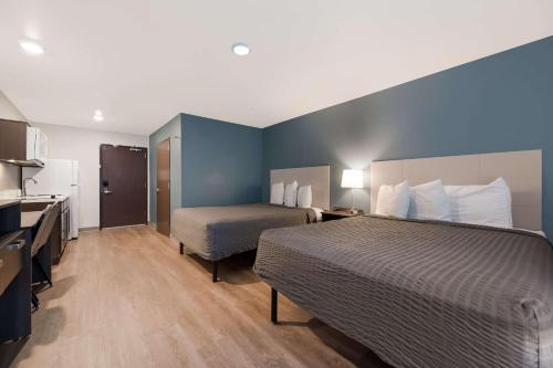 フェニックスにあるWoodSpring Suites Phoenix-Deer Valleyのベッドとキッチン付きのホテルルーム