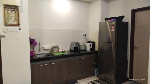 a kitchen with a black counter and a refrigerator at GWE Homestay in Bayou Lagoon Waterpark Resort Melaka in Malacca