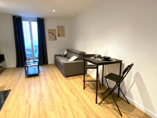 een woonkamer met een bank en een tafel bij Le Loft Levis in Parijs