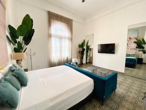 een slaapkamer met een groot bed en een televisie bij AmazINN Places Casco Viejo Pool and Rooftop VIII in Panama-Stad