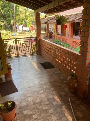 a patio with a brick wall with lights on it at Kedige Homestay in Kumta