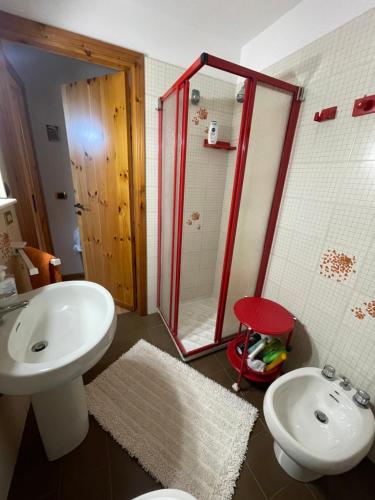 Un baño con lavabo, inodoro y ducha. en Monolocale al BlueMarine, en Riposto
