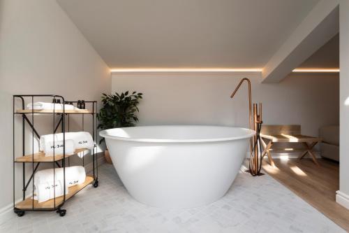 a white bath tub in a bathroom with towels at ICON Malabar in Málaga