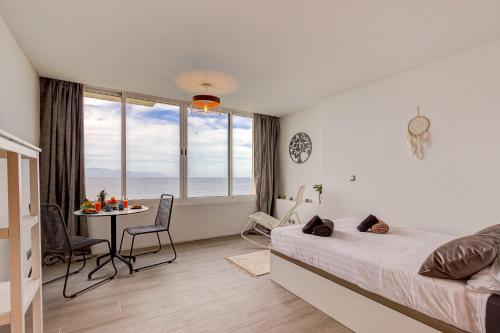 1 dormitorio con cama, mesa y ventana en Ocean Loka, en Callao Salvaje
