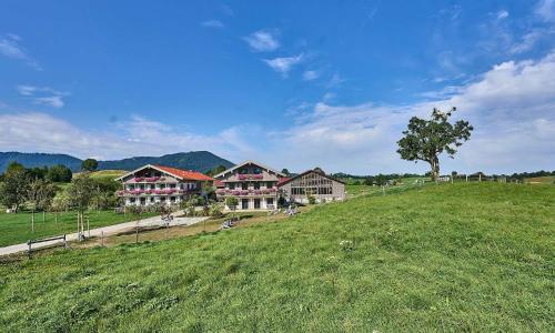 a large house on a hill in a field at Hof Hauserbichl in Fischbachau