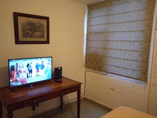 een woonkamer met een televisie op een houten tafel bij Departamento los Mangos in Puerto Vallarta