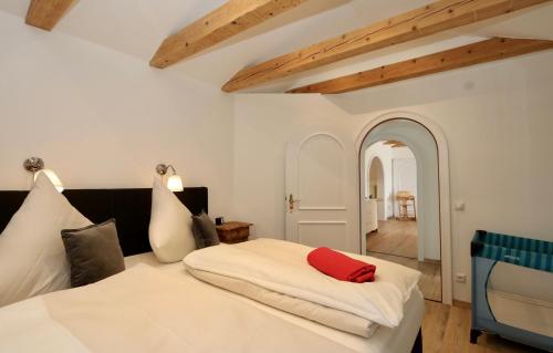 um quarto com uma cama branca e uma almofada vermelha em Alpengold em Garmisch-Partenkirchen