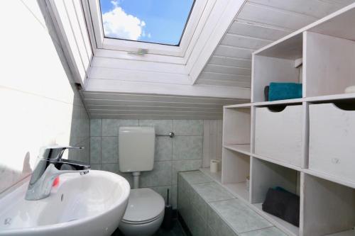 uma casa de banho com um lavatório, um WC e uma clarabóia em Alpengold em Garmisch-Partenkirchen