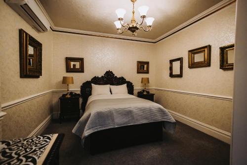 a bedroom with a bed and a chandelier at Brook Hall Hotel in Childer Thornton