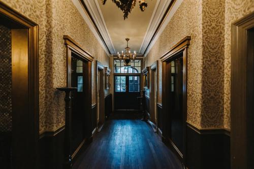 an empty hallway of a building with a chandelier at Brook Hall Hotel in Childer Thornton